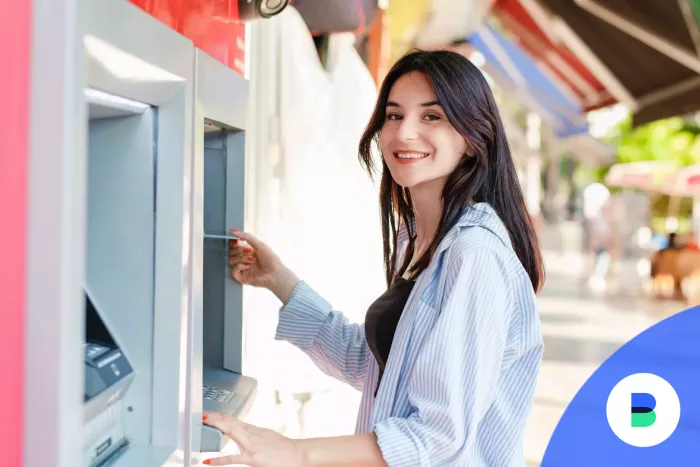 Diáklány bedugja a bankkártyáját az ATM-be