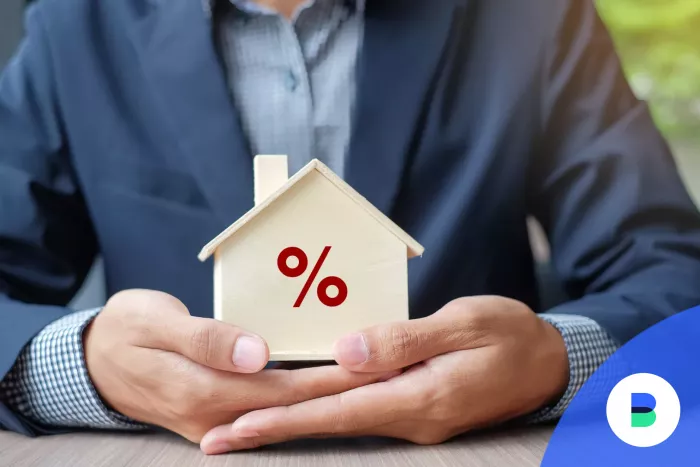 Férfi mutatja egy házban a kh lakáshitel százalékos költségeit